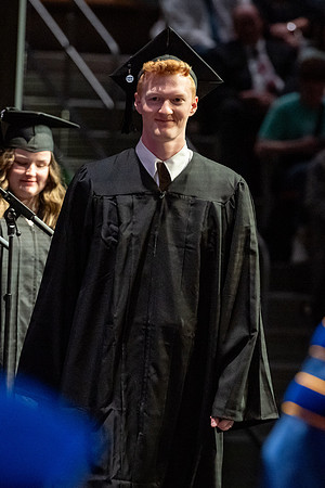 Graduates walk across the stage.