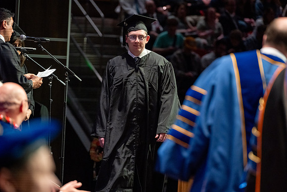 Graduates walk across the stage.
