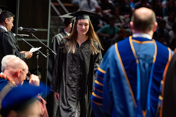 Graduates walk across the stage.