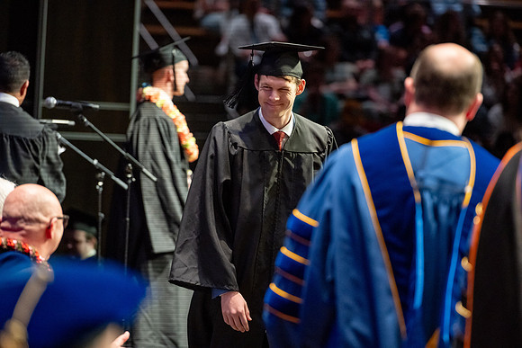 Graduates walk across the stage.