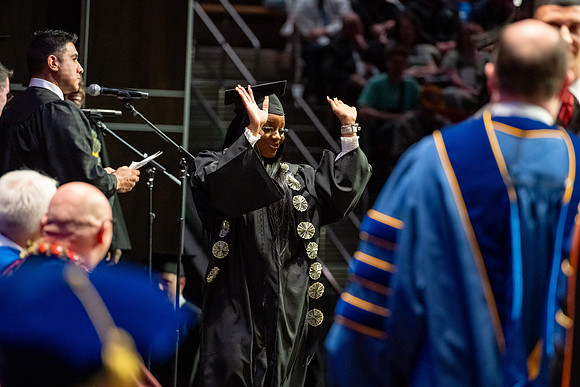 Graduates walk across the stage.
