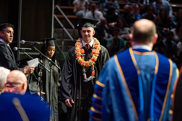 Graduates walk across the stage.