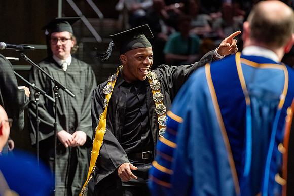 Graduates walk across the stage.