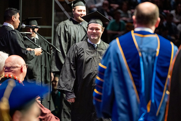Graduates walk across the stage.