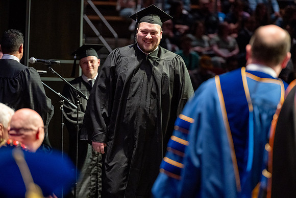 Graduates walk across the stage.