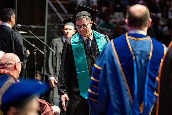 Graduates walk across the stage.