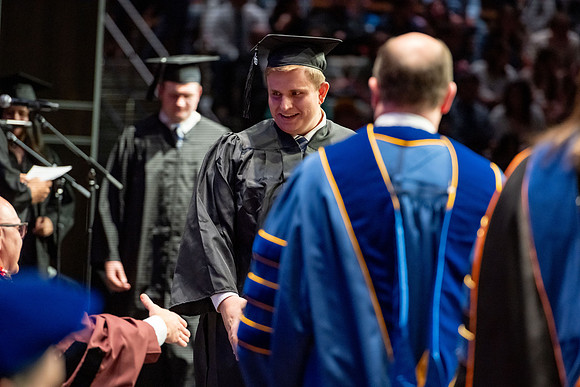 Graduates walk across the stage.