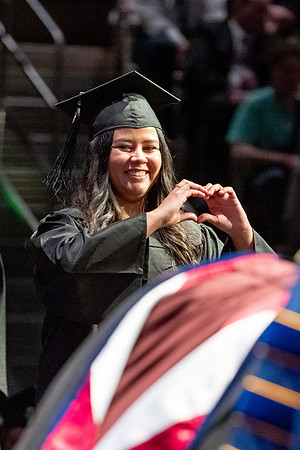 Graduates walk across the stage.