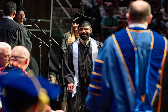 Graduates walk across the stage.