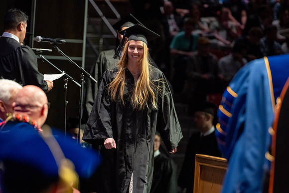 Graduates walk across the stage.