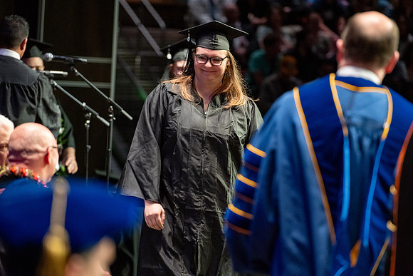 Graduates walk across the stage.