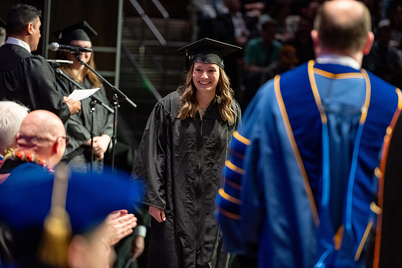 Graduates walk across the stage.