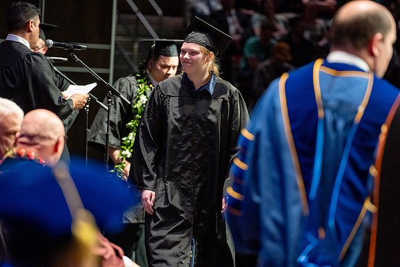 Graduates walk across the stage.