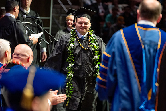 Graduates walk across the stage.