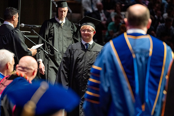 Graduates walk across the stage.