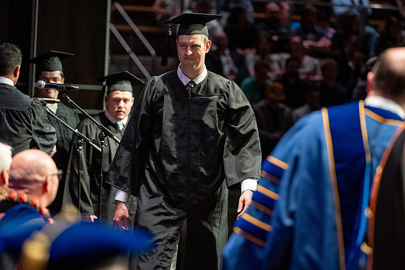 Graduates walk across the stage.