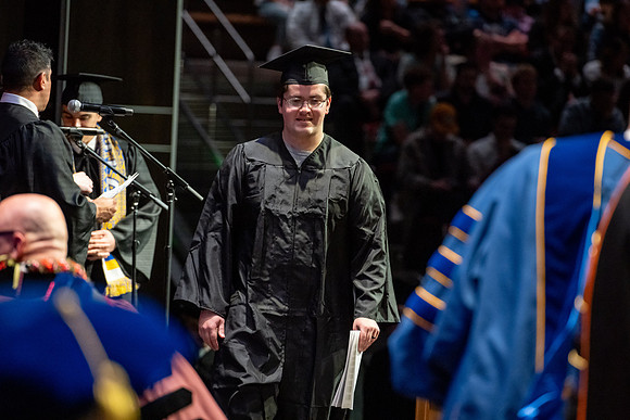 Graduates walk across the stage.
