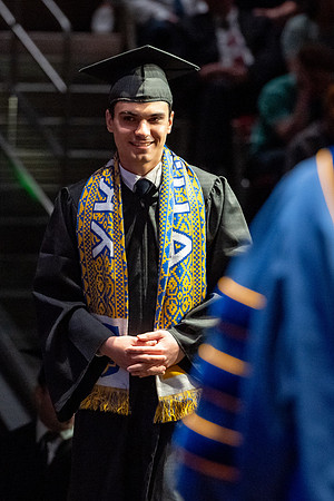 Graduates walk across the stage.