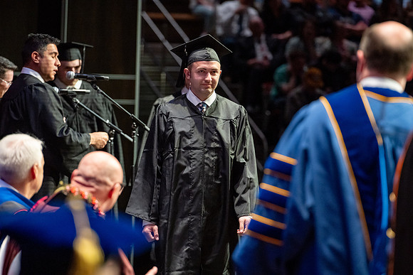 Graduates walk across the stage.
