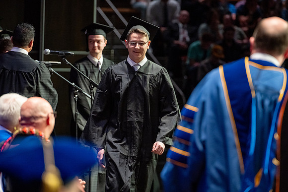 Graduates walk across the stage.