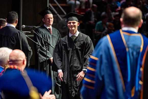 Graduates walk across the stage.