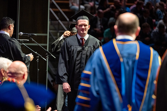 Graduates walk across the stage.