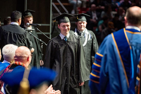 Graduates walk across the stage.
