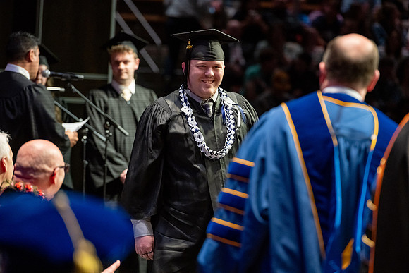Graduates walk across the stage.