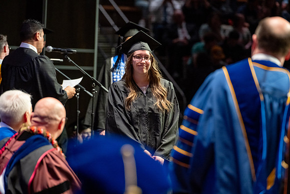 Graduates walk across the stage.