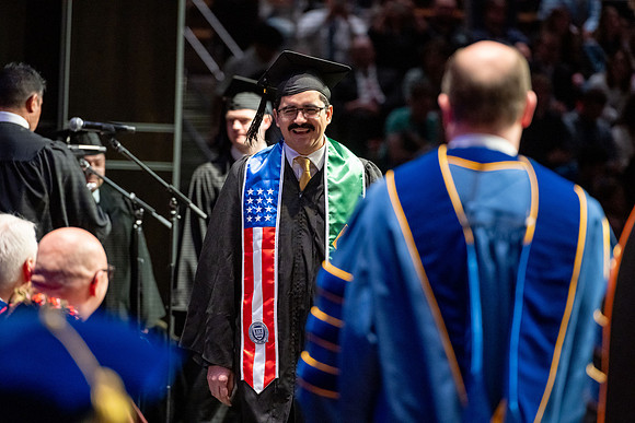 Graduates walk across the stage.