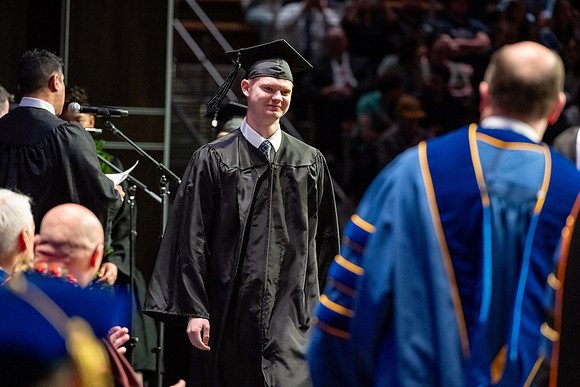 Graduates walk across the stage.