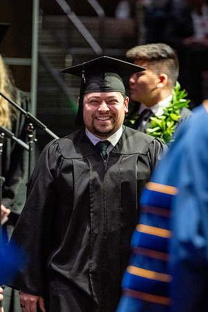 Graduates walk across the stage.