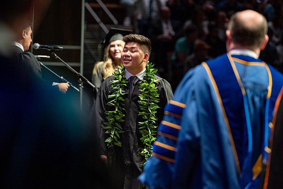 Graduates walk across the stage.