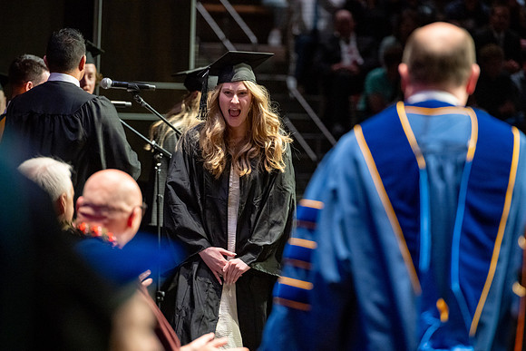 Graduates walk across the stage.