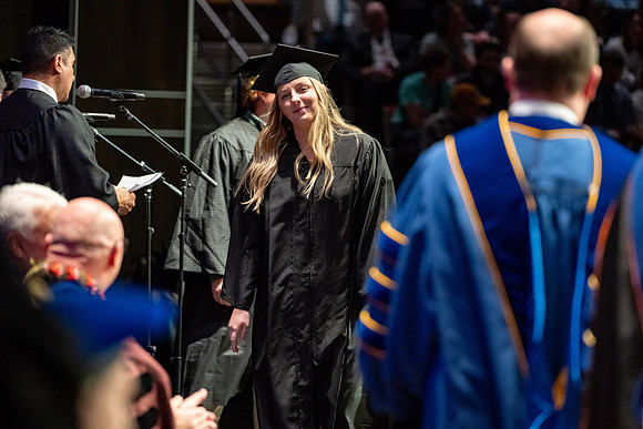 Graduates walk across the stage.