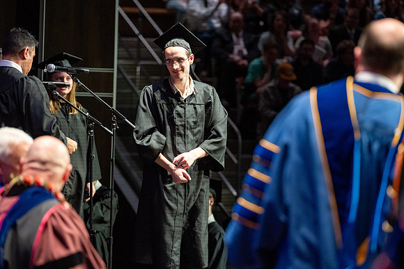 Graduates walk across the stage.