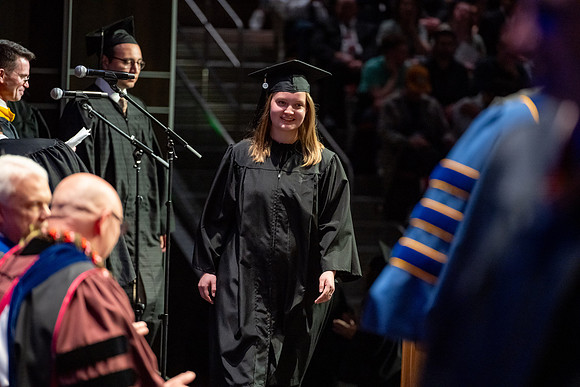 Graduates walk across the stage.
