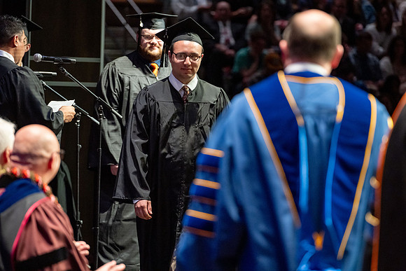 Graduates walk across the stage.