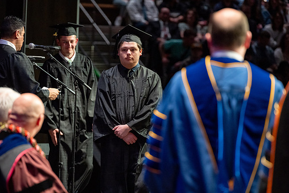 Graduates walk across the stage.