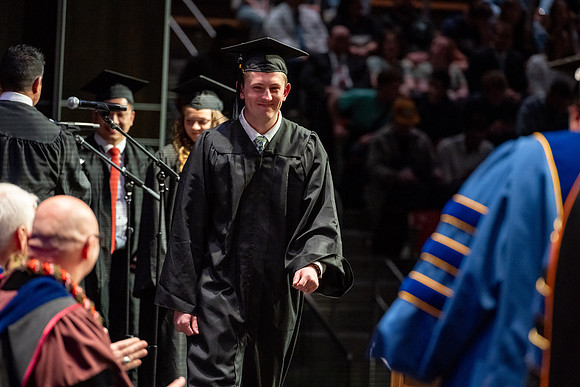 Graduates walk across the stage.