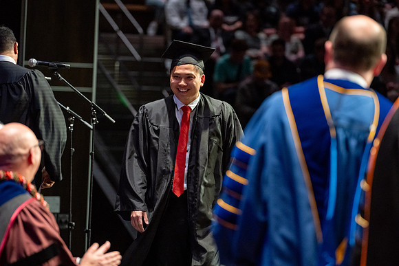 Graduates walk across the stage.