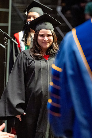 Graduates walk across the stage.