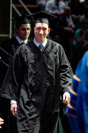 Graduates walk across the stage.