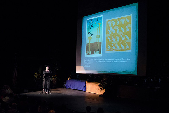Clairissa Shaw, Bachelor of Fine Arts with an emphasis in Two-Dimensional Studies, gives a visual arts presentation during convocation in the Snow Building.
