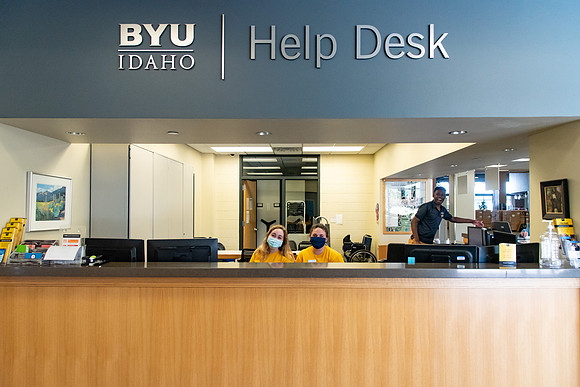 Student employees wearing face masks and working at the Help Desk during the Covid-19 Pandemic.