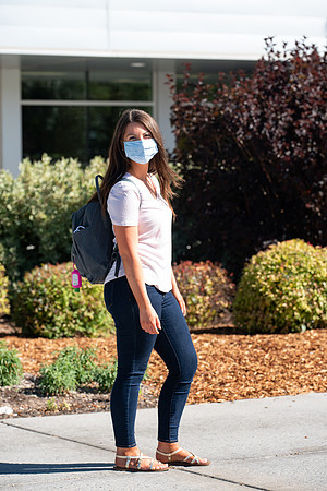 Examples of students staying safe and healthy during the COVID-19 pandemic by social distancing, following pathway arrows, and wearing face masks.