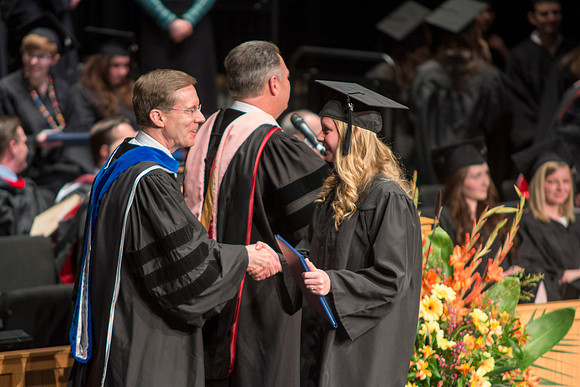 Faculty members hand degrees to and congratualate graduates of the College of Performing and Visual Arts.