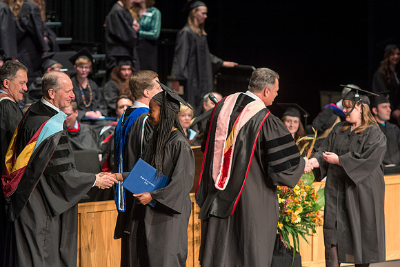 Faculty members hand degrees to and congratualate graduates of the College of Performing and Visual Arts.