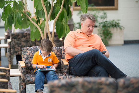 Father watches son while waiting for wife.