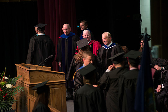 Elder W. Craig Zwick and President Kim B. Clark award diploma covers to graduates in the College of Business and Communication.